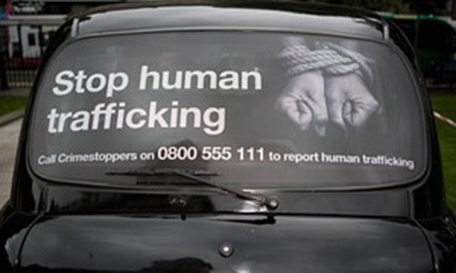Oglas na taksiju koji promoviše podizanje svesti o trgovini ljudima u Severnoj Irskoj. Fondacija za borbu protiv trgovine ljudima navodi u svom izveštaju da ranjive osobe propadaju kroz ‘praznine’ koje postoje u državnoj zaštiti. Fotografija: Alamy